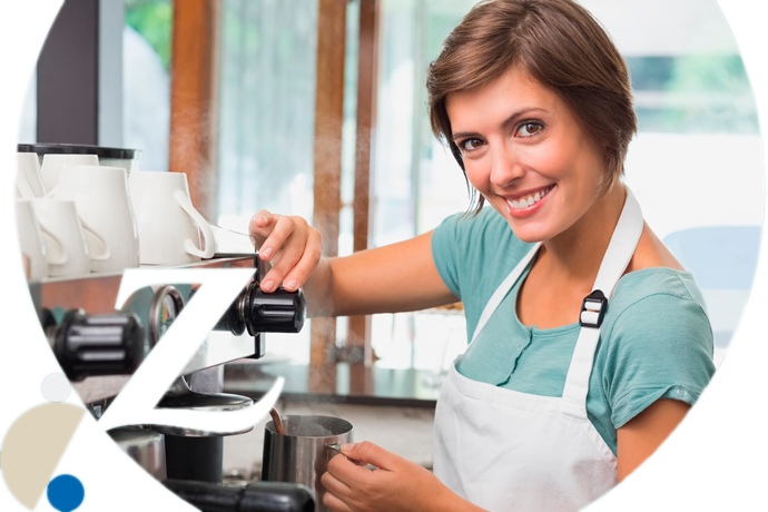 trabajadora de una cafetería calentando leche en la cafetera