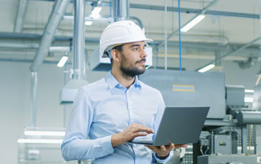 persona con ordenador en sala de máquinas