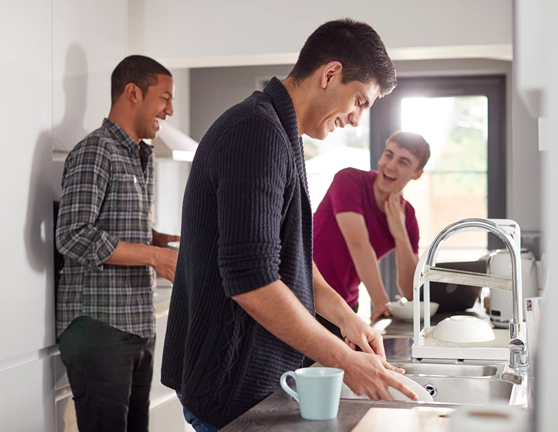 Compañeros de piso riendo en la cocina