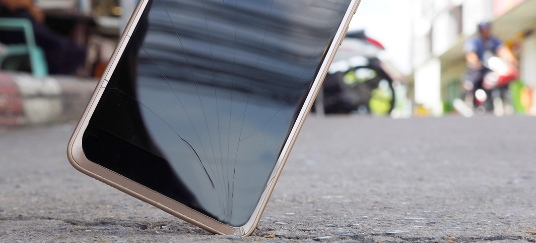Smartphone cayendo al suelo y mostrando la pantalla rota